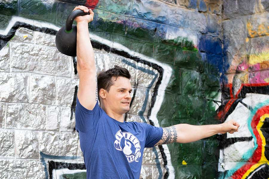 Philipp Widermann trainiert mit einem 24kg Kettlebell über seinem Kopf.